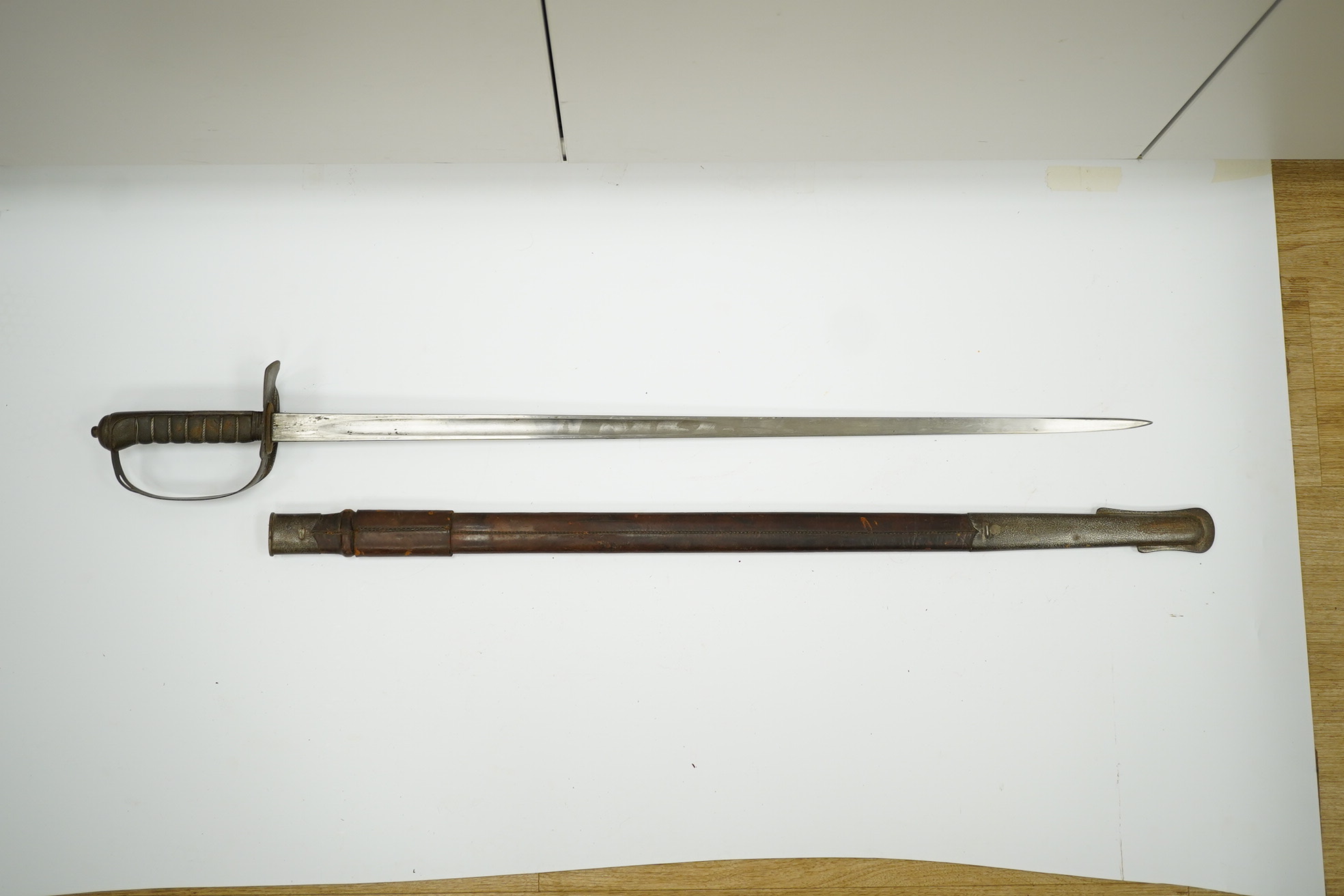 A mid-19th century British infantry sword, by Mole, Birmingham, marked I.S.D., in its leather scabbard with iron chape. Condition - poor, surface rust and knuckle guard significantly cut down.